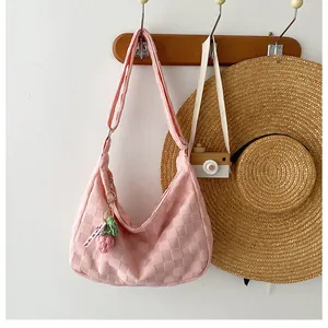 Close-up of pink waffle texture shoulder bag with cute knit strawberry charm detail