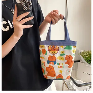 Détail d'un sac seau en toile avec imprimé tigre mignon et anses bleues en tissu