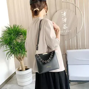 Elegante borsa a secchiello in pelle nera da donna con catena d'oro e tracolla regolabile