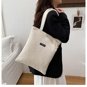 Dettaglio della trama della borsa tote in velluto bianco con etichetta moda e tracolla