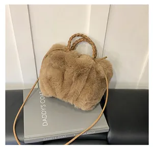 Détail du sac bandoulière en peluche camel avec poignée tissée et fausse fourrure