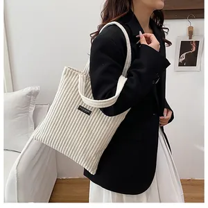 Dettaglio della borsa tote in velluto a coste bianco con etichetta Fashion e trama