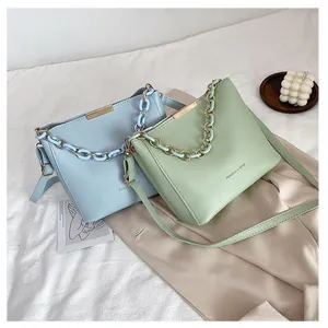 Borse a secchiello minimaliste azzurre e verde menta con barre dorate e manici a catena