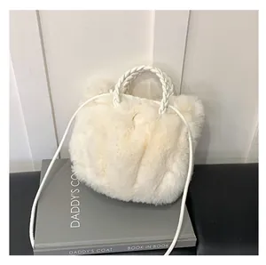 Détail du sac à main en fausse fourrure blanche douce avec poignées en cuir tressé