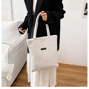 Dettaglio della borsa tote in velluto a coste bianco con trama e toppa fashion