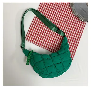 Close-up of green quilted hobo bag featuring soft puffer texture and adjustable strap