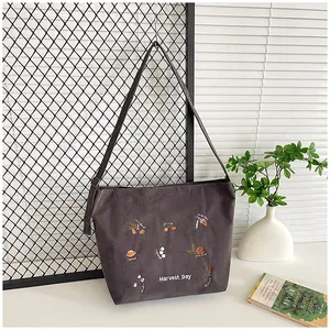 Detail of dark gray corduroy tote featuring Harvest Day embroidery and textured finish