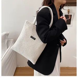 Dettagli del tessuto del sacchetto tote in velluto a coste bianco con tracolla e logo