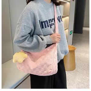 Pink waffle-textured shoulder bag detail featuring a cute yellow bear plush charm