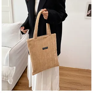 Dettaglio della borsa tote in velluto a coste kaki con trama a righe e etichetta