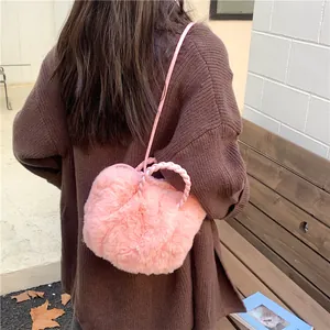 Sac à main en fausse fourrure rose avec poignées tressées et bandoulière en extérieur