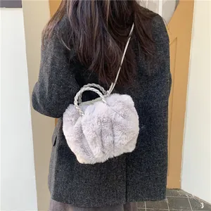 Sac bandoulière en peluche lavande avec anses tressées porté sur un manteau