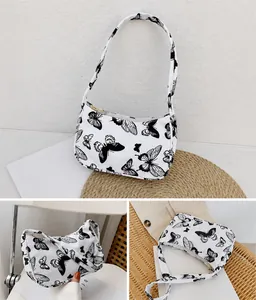 Détail du sac papillon blanc avec fermeture éclair dorée et texture de tissu raffinée