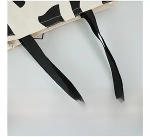 Detail of the soft black and white spotted canvas tote bag with a durable zipper closure