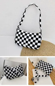 Trois vues d'un sac baguette à damier noir et blanc avec fermeture éclair et sangle