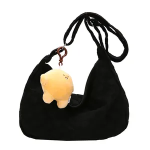 Black waffle texture tote bag with shoulder strap and yellow plush charm accessory