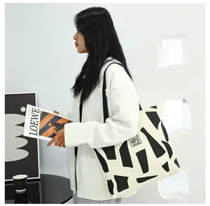 Detail of canvas tote bag showing the GOOD STUDENT label and abstract black patterns