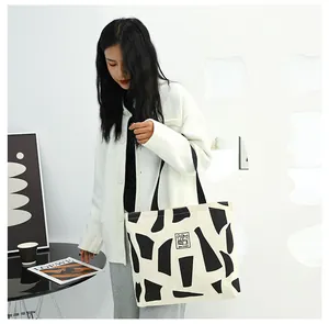 Detail view of large canvas tote bag with geometric print and double black shoulder straps