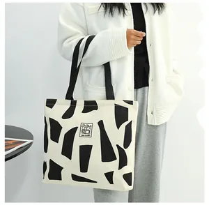 Detail of canvas tote bag showing black geometric patterns and woven Good Student label