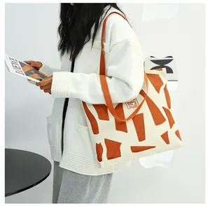 Detail of canvas tote bag with orange geometric print and durable shoulder straps