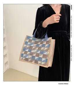 Detail of checkered woven canvas tote bag showing blue and brown plaid pattern