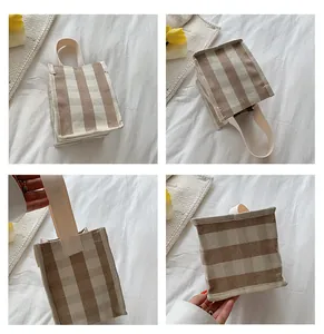 Détails du sac à main en toile à rayures marron montrant la texture et l'anse crème