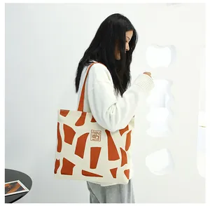 Detail of canvas tote bag with orange geometric patterns and Good Student rabbit patch