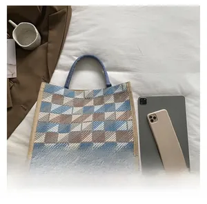 Detailed view of checkered canvas tote bag with woven texture on a minimalist background