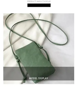 Detail view of green canvas mini phone crossbody bag with textured fabric surface