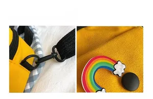 Detailed macro view of yellow canvas bag with rainbow decor and black plastic hooks
