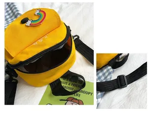 Detail of yellow canvas mini bag featuring a rainbow patch and adjustable strap