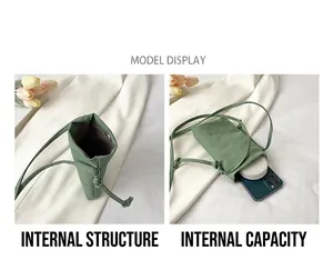 Detail view of mini green canvas bag interior showing storage space for phone and makeup