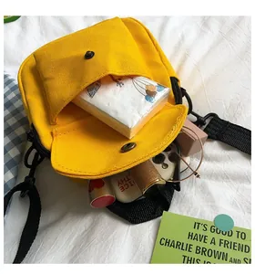 Detail view of yellow canvas crossbody bag interior showing tissues, glasses, and daily items