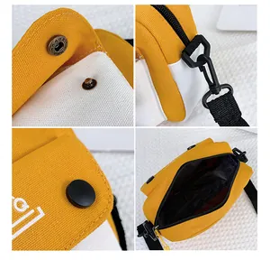 Detail view of yellow canvas bag featuring metal snap, zipper, and adjustable strap