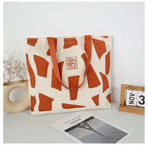 Detail of canvas tote bag with orange geometric pattern and cartoon rabbit label