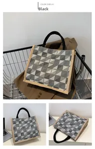 Detail of grey diamond patterned canvas tote bag with black tubular handles in a cart