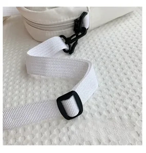 Detail of adjustable white nylon strap and black plastic buckle on the shoulder bag
