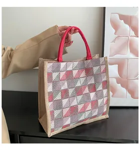 Detail of red and grey checkered canvas tote bag with vibrant pink woven handles