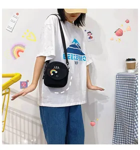 Close-up of black canvas crossbody bag featuring rainbow patch and adjustable strap
