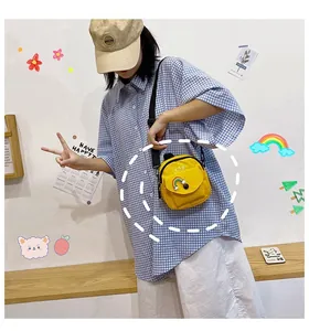 Yellow canvas crossbody bag with rainbow patch and adjustable strap shown on a model