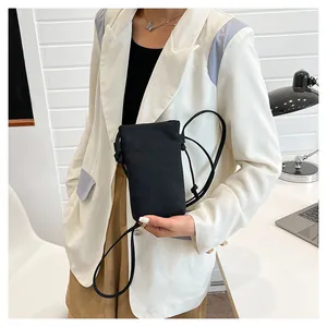 Model met een kleine zwarte canvas crossbody tas voor mobiele telefoon met trekkoord