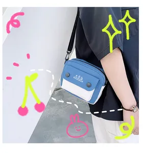 Blue and white canvas crossbody bag detail showing the snap-button flap and KÕQ logo