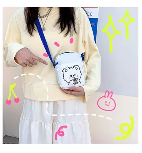 Detalle de bolso bandolera de lona blanca con un lindo oso bebiendo té de burbujas