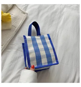 Détail du mini sac cabas en toile à rayures bleues et blanches avec anses larges