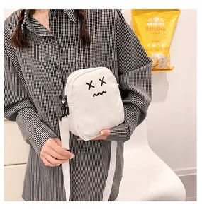 White nylon crossbody bag featuring a minimalist cartoon face and white shoulder strap