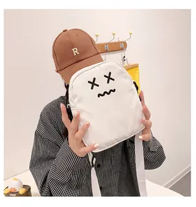Detail of white nylon crossbody bag featuring minimalist cartoon embroidery and strap