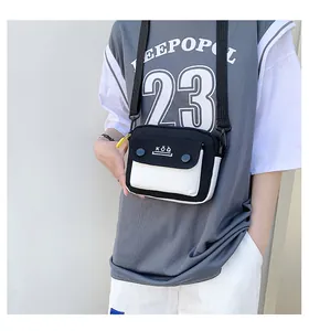 Close-up of black and white canvas crossbody bag with adjustable wide nylon strap
