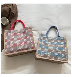 Top view of two plaid woven canvas tote bags with red and blue handles in a cozy setting