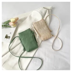 Detail van minimalistische groene stoffen en crème geweven telefoontasjes met knoopriemen