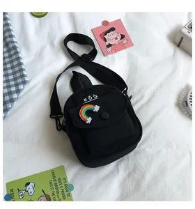 Detail of black canvas mini crossbody bag with rainbow embroidery on white background